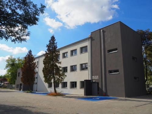Nowoczesny budynek Centrum Grawitacja z przestronnym parkingiem i wejściem głównym, przeznaczony do prowadzenia terapii, szkoleń i wydarzeń edukacyjnych. 